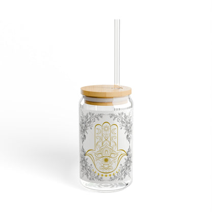Glass tumbler with floral pattern, wooden lid, and straw on a white background