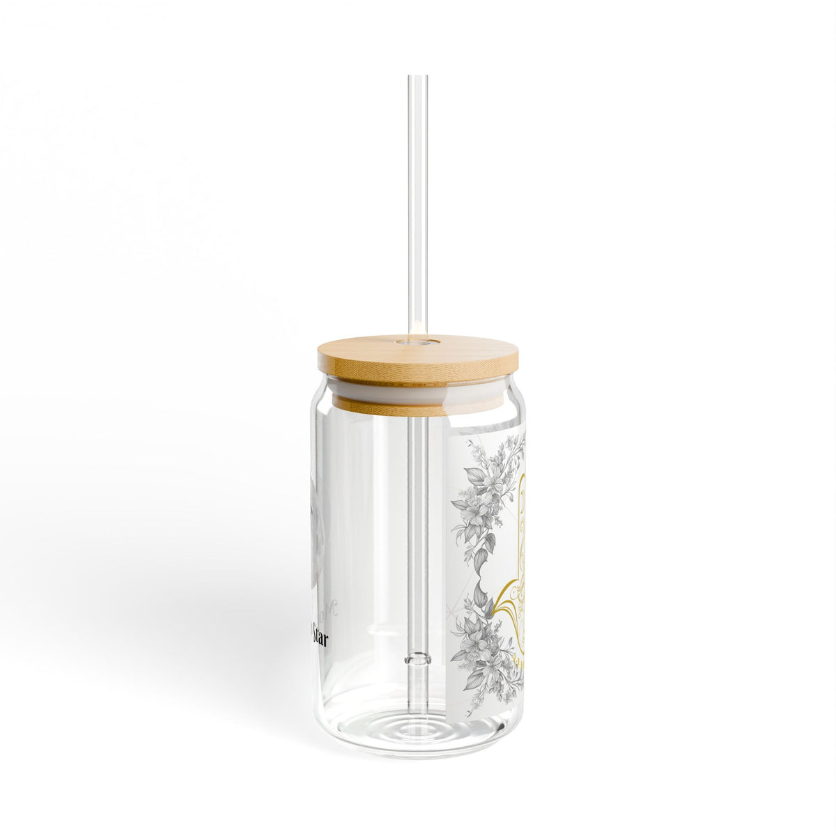 A clear glass tumbler with a bamboo lid and a clear straw, decorated with a delicate gray and gold botanical pattern on the side, set against a plain white background.