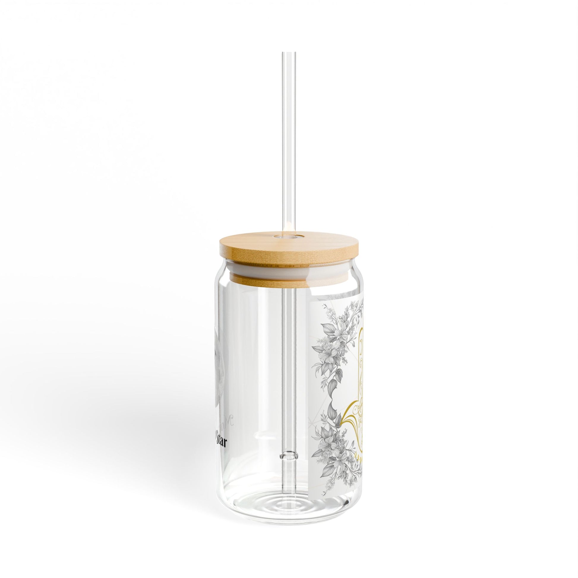 A clear glass tumbler with a bamboo lid and a clear straw, decorated with a delicate gray and gold botanical pattern on the side, set against a plain white background.