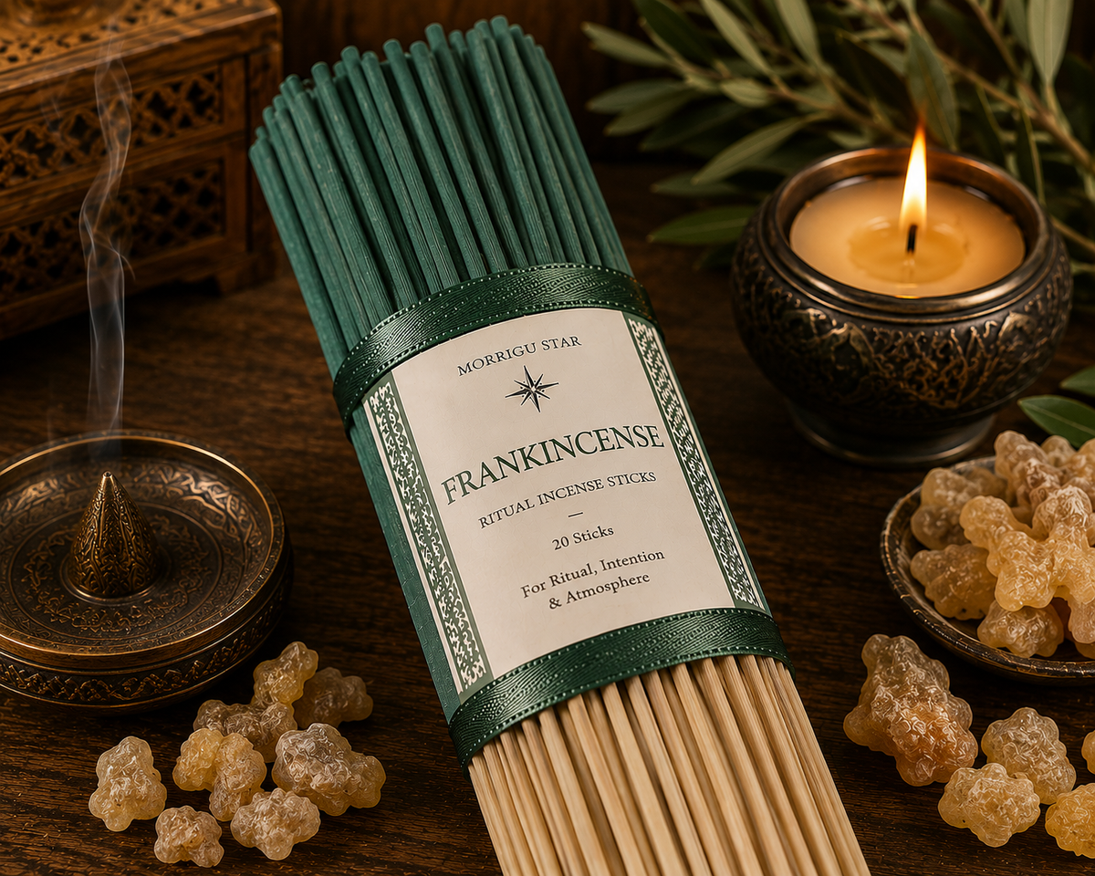A bundle of Morrigu Star Frankincense ritual incense sticks in a dark green paper sleeve, styled on a dark wooden surface with a burning candle, an incense burner, and natural resin pieces.