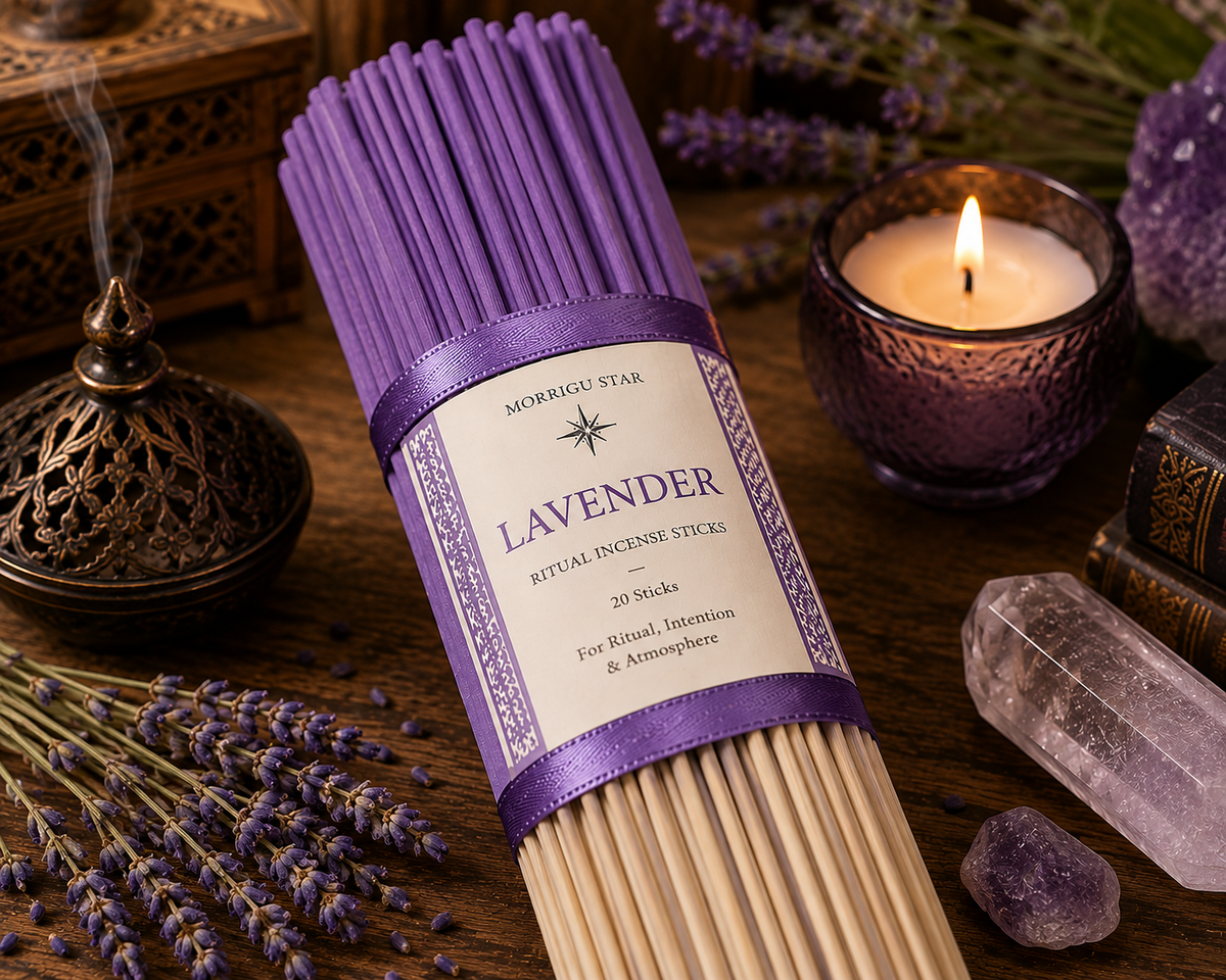 A bundle of Morrigu Star lavender ritual incense sticks in a purple ribbon-wrapped package, displayed on a wooden surface with lavender sprigs, a lit candle, a brass incense burner, and crystals.