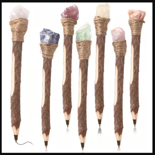A decorative pens with wood-grain handles, wrapped twine at the top, and natural crystal tips in pink, blue, green, and white