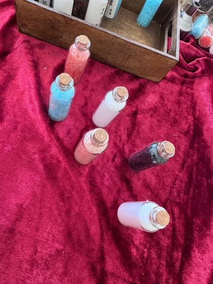 Six Morrigu Star ritual salt bottles displayed on burgundy velvet